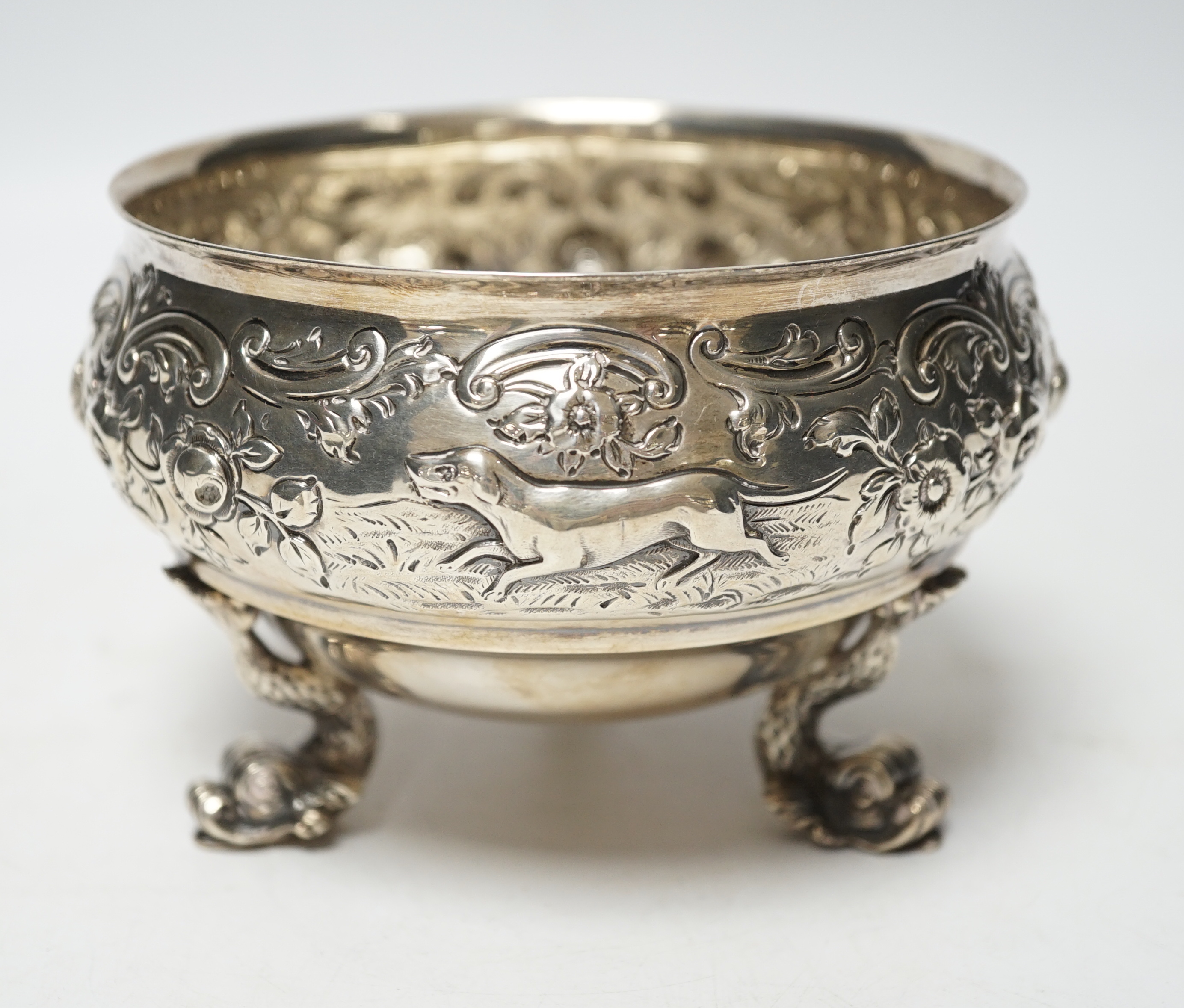 An Edwardian embossed silver bowl, on three dolphin supports, Wakely & Wheeler, London, 1905, diameter 11.6cm, 11.4oz.